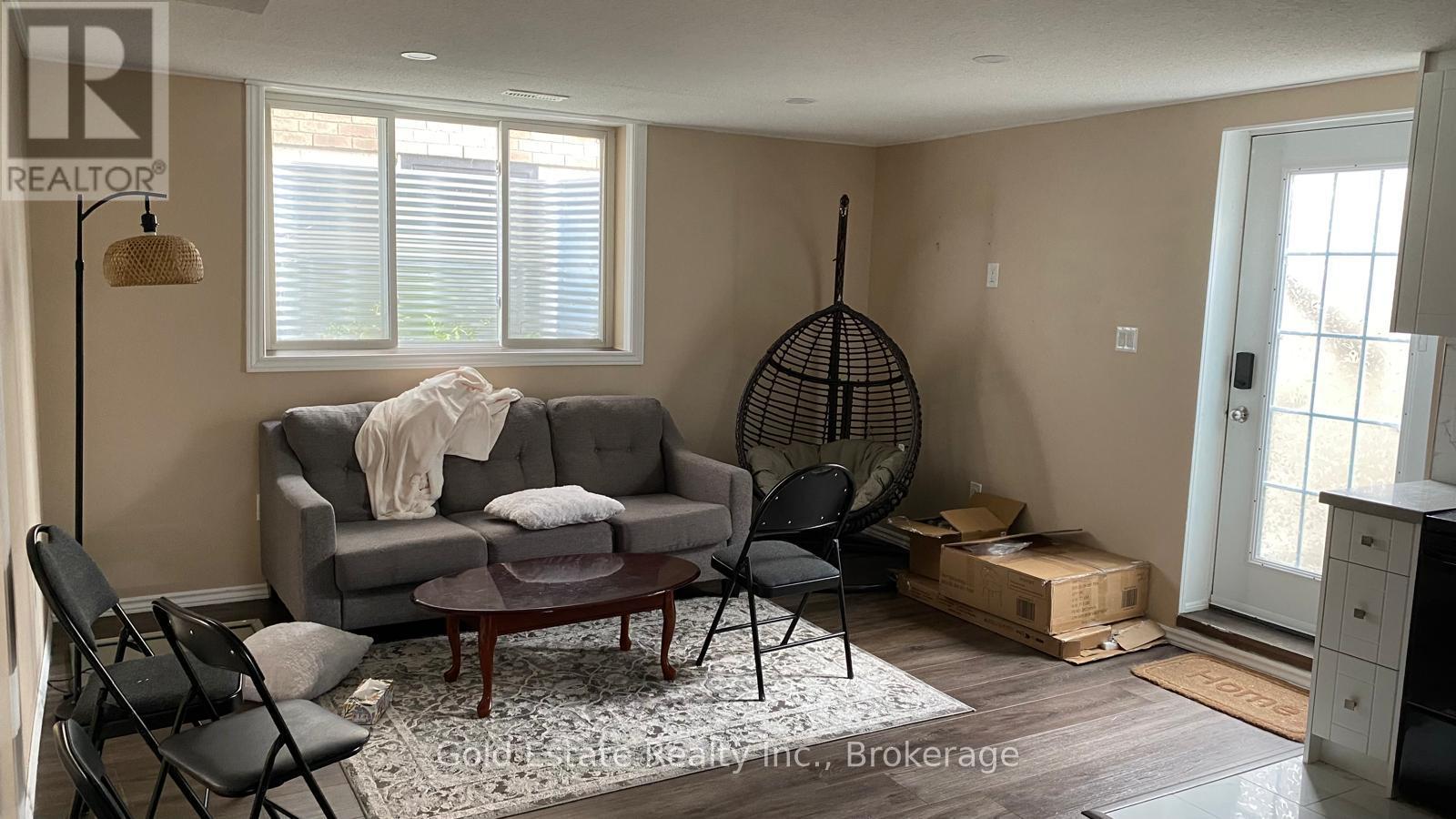 A living room with a grey couch, a black chair, and a wooden coffee table.
