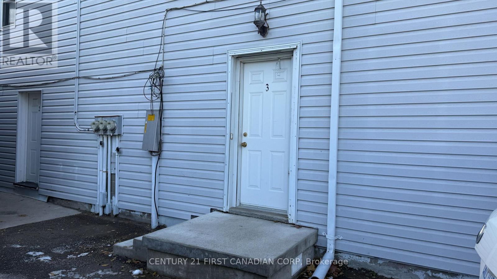 A white door is on the side of a house.