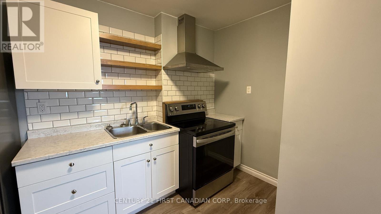 A kitchen with white cabinets and a black stove top oven.