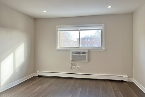 A room with a window and a radiator on the wall.