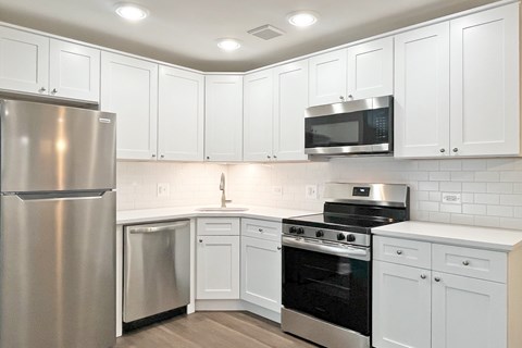 A kitchen with white cabinets and stainless steel appliances.