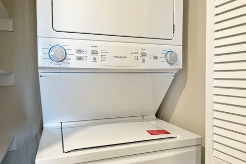 A white dryer with a red sticker on the bottom.