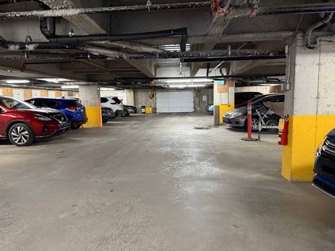 A parking garage with a red car parked in the foreground.