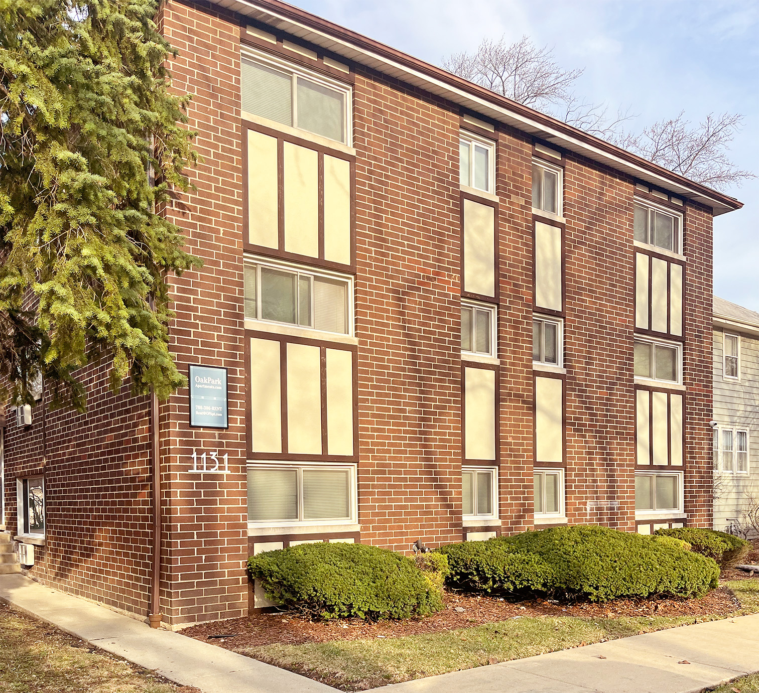 A red brick building with a blue sign on the left side.