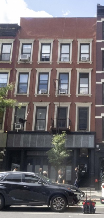 A black car is parked on the side of the street.