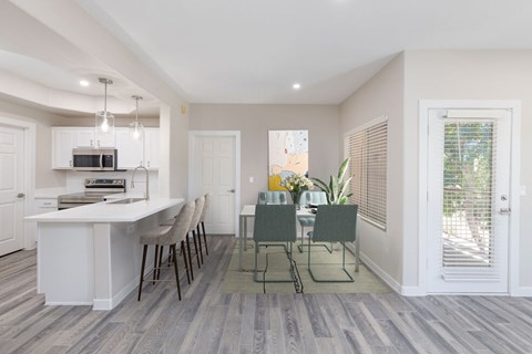 A kitchen with a dining table and chairs.
