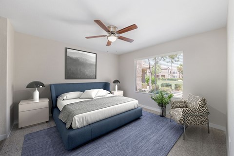 A bedroom with a blue bed and a ceiling fan.