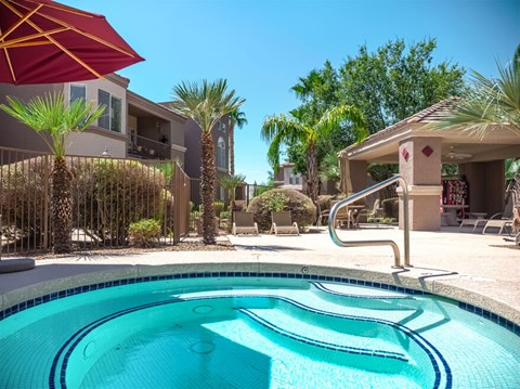 A pool with a slide and a building in the background.