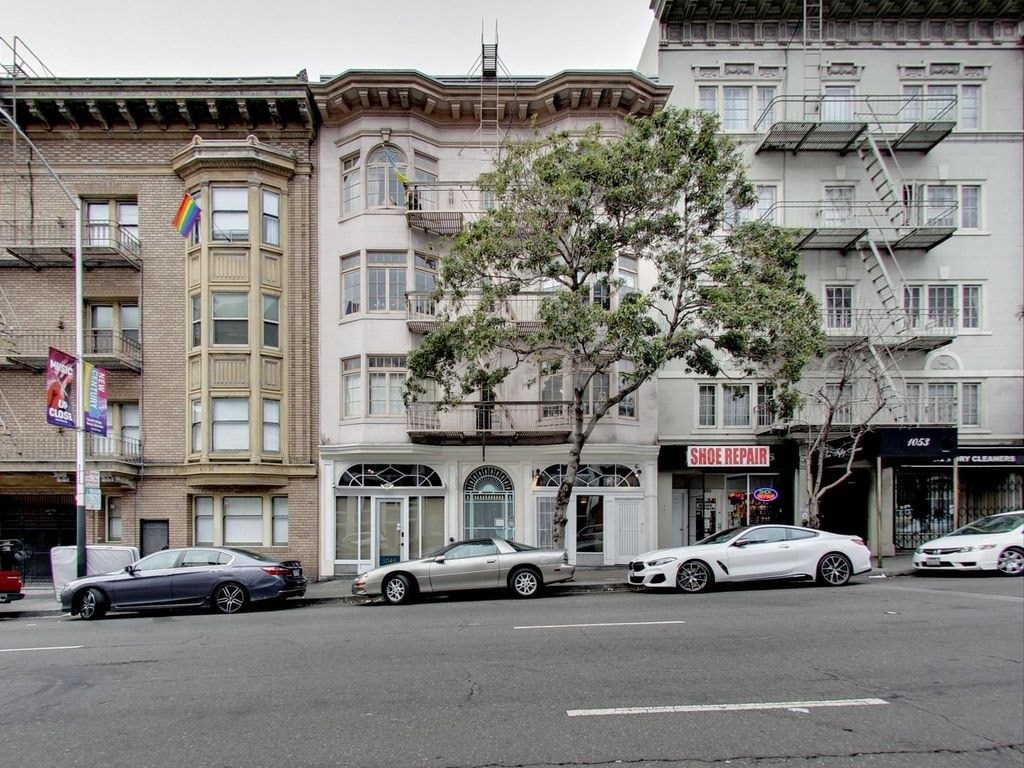 A row of parked cars in front of a building with a sign that says "Slide Repair".