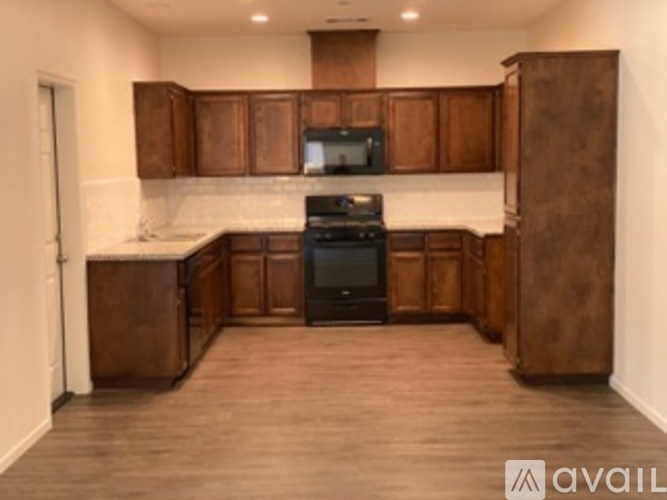 A kitchen with brown cabinets and a black stove top oven.