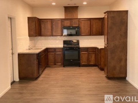A kitchen with brown cabinets and a black stove top oven.