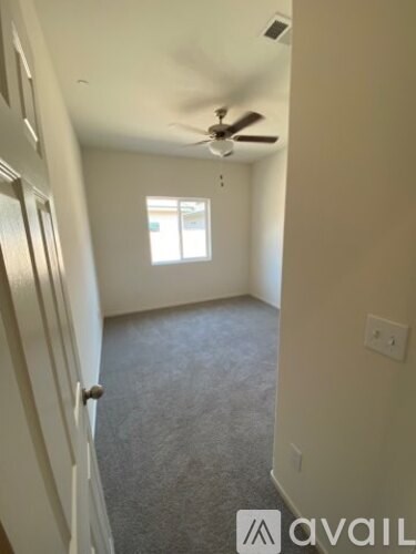 A room with a ceiling fan and a window.