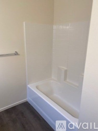 A white bathtub in a bathroom with a grey floor.