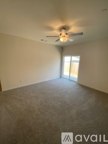 A room with a ceiling fan and carpeted floor.