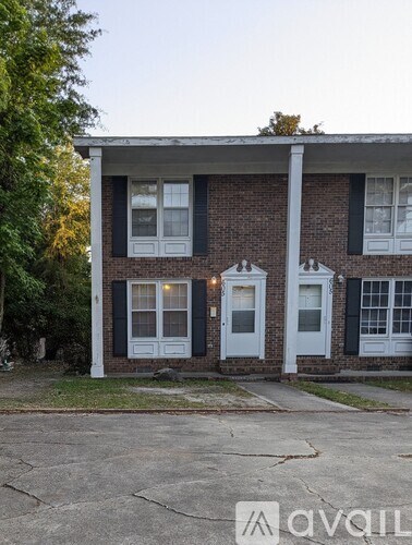 A house with a white door and black shutters is shown.