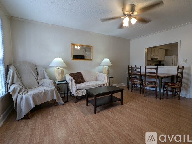 A living room with a couch, chairs, and a coffee table.