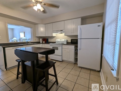 A kitchen with a table and chairs.