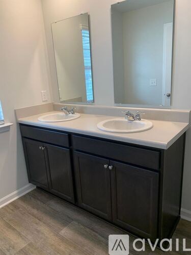 A bathroom vanity with two sinks and a large mirror.