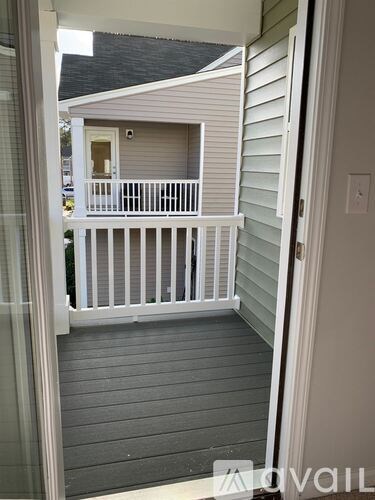 A balcony with a white railing and a glass door.