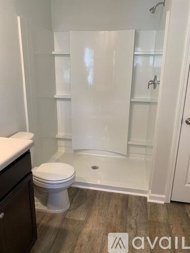 A white toilet sits in a bathroom with a glass shower door.