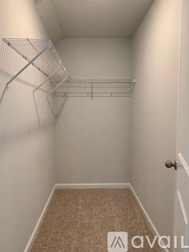 A small, empty room with a carpeted floor and a door on the right.