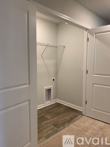 A white closet with a carpeted floor and a white door.