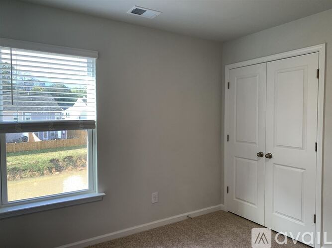 A white door is in a room with a window.