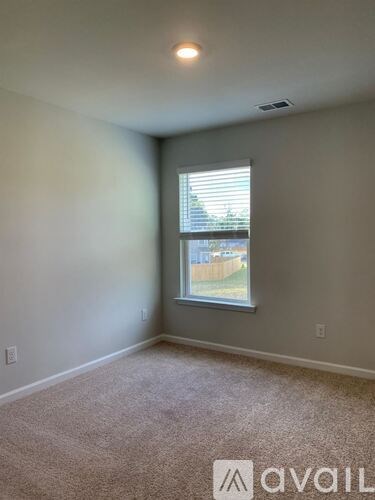 A room with a window and carpeted floor.