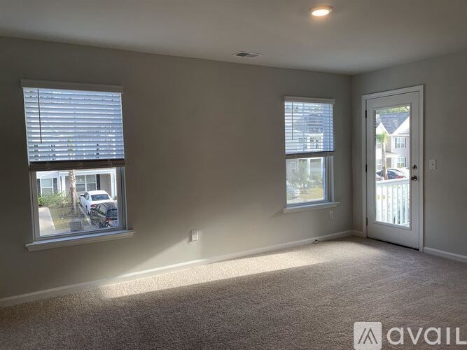 A room with two windows and a door is available for rent.
