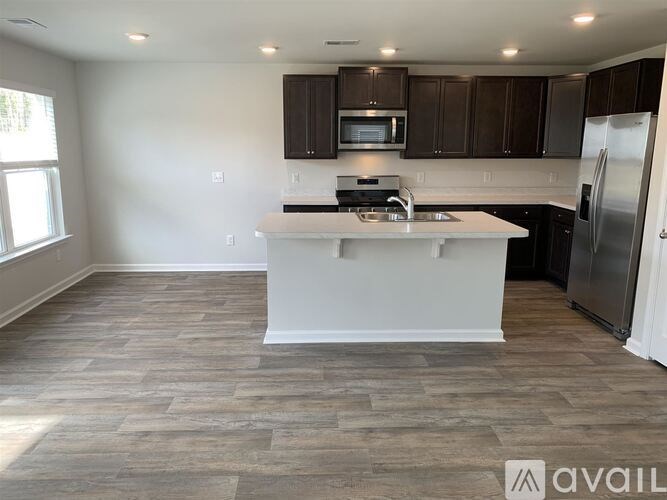 A kitchen with a white countertop and wooden cabinets.