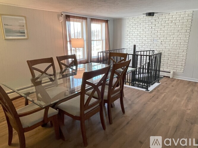 A dining room with a glass table and chairs.