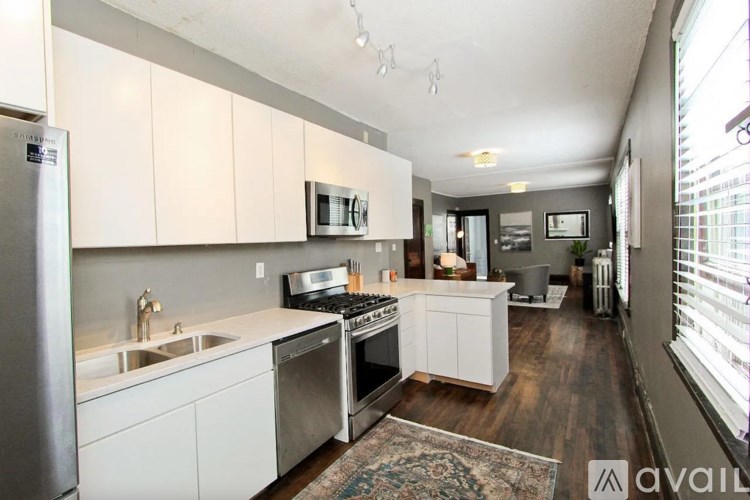 A modern kitchen with white cabinets and stainless steel appliances.
