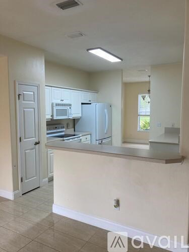A kitchen with white cabinets and appliances.