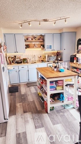 A kitchen with a table and a refrigerator.