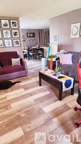 A living room with a red couch and a wooden floor.