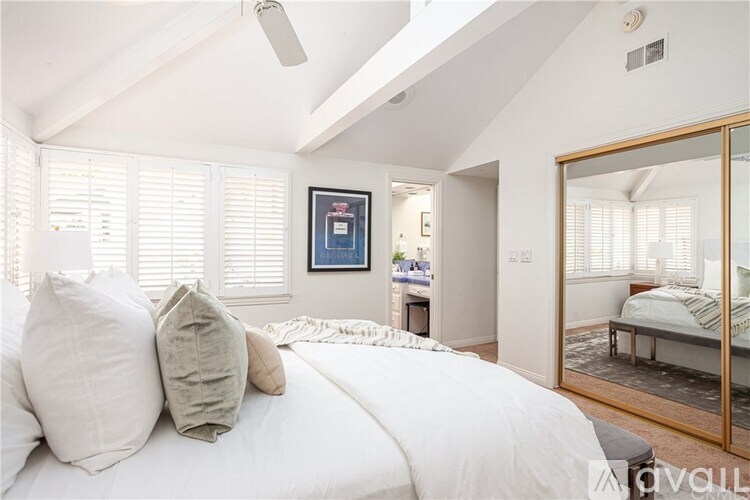 A bedroom with a large bed and a painting on the wall.