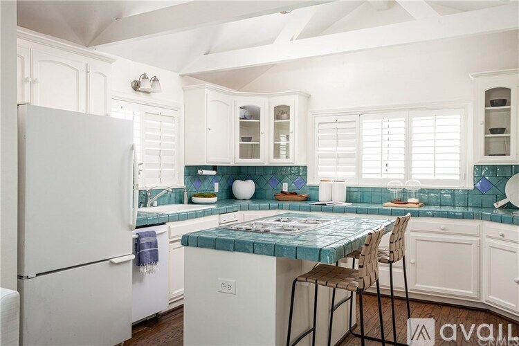A kitchen with a white refrigerator and a table with chairs.