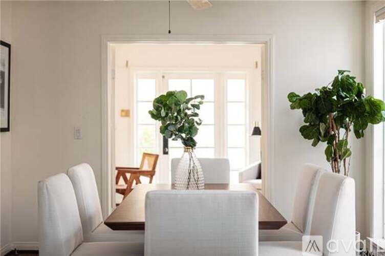 A white dining room with a table and chairs.