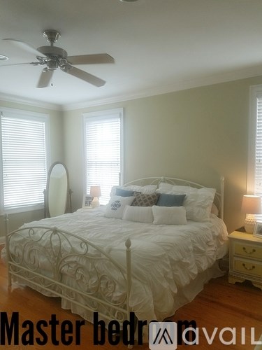 A bedroom with a large bed and a ceiling fan.