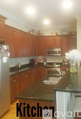 A kitchen with wooden cabinets and granite countertops.