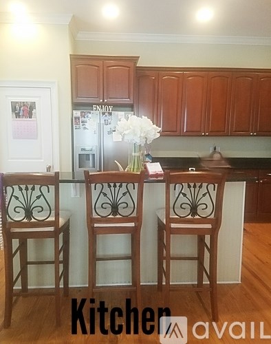 A kitchen with a bar and chairs in front of it.