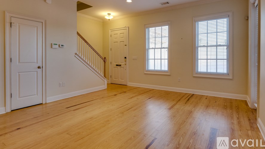 A spacious room with wooden floors and white walls.