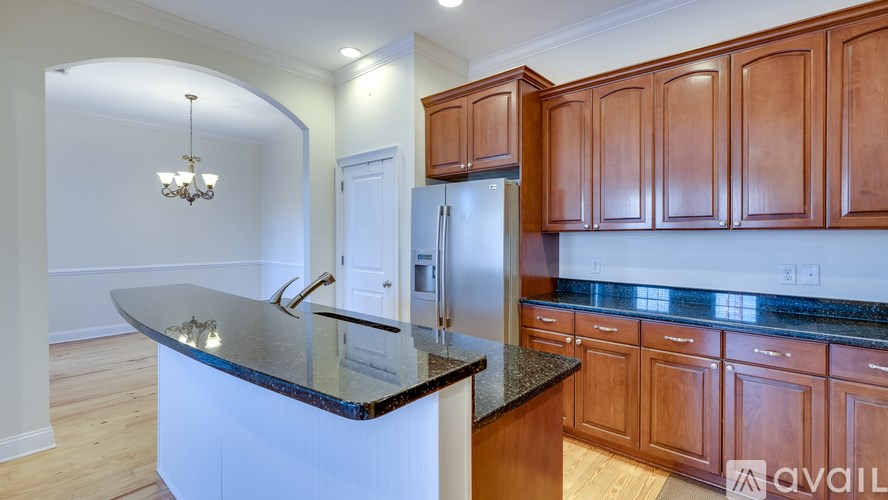 A kitchen with wooden cabinets and a black countertop.