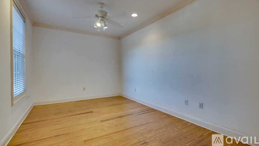A room with wooden flooring and a ceiling fan.