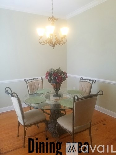 A dining table with chairs and a chandelier in a room.