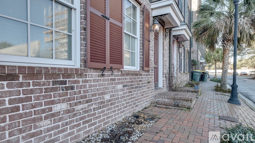 A brick building with a sign that says "AVAIL" in the foreground.