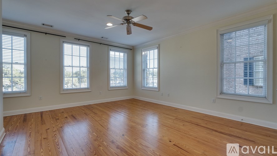 A room with wooden flooring and a ceiling fan.