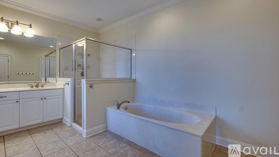A white bathroom with a tub, sink, and mirror.