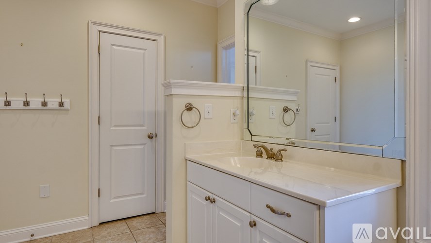 A bathroom with a white vanity and a white door.