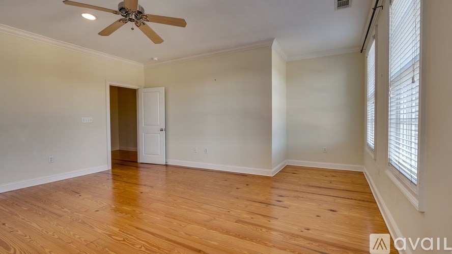 A room with a ceiling fan and wooden flooring.